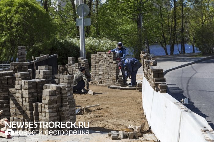 Рабочие перекладывают "пляшущую" плитку на мосту через р. Малая Сестра